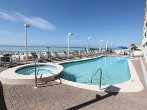 a swimming pool with chairs and the ocean in the background at Seychelles Resort by Panhandle Getaways in Panama City Beach