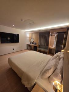 a bedroom with a large bed and a television at The Van Stay in Busan +60 photos
