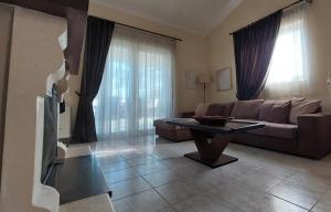 a living room with a couch and a table at Villa Alexandra Rio Patra in Áyios Vasílios