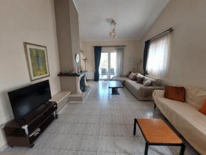 a living room with a couch and a table at Villa Alexandra Rio Patra in Áyios Vasílios