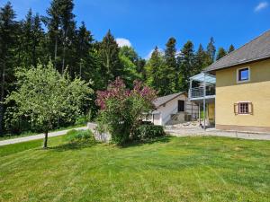 a house with a tree in the yard at Ferienwohnung Hüttenbauer in Dorf