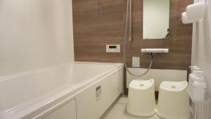 a white bathroom with a tub and a toilet at Sakura View Nagoya Stay Hub in Nagoya