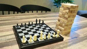 a chess board on a table next to a stack of dominoes at Sakura View Nagoya Stay Hub in Nagoya +26 photos