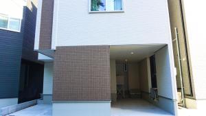 a building with a brick wall and an open door at Sakura View Nagoya Stay Hub in Nagoya