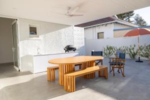 a kitchen and dining room with a wooden table and chairs at Belle Escapes Henley's Coastal Charm in Henley Beach South