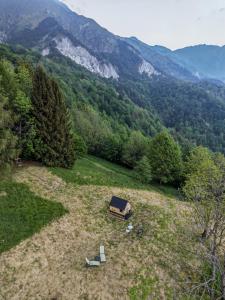 a house and two chairs in a field with mountains at StarsBOX - La Vrata Gialla in Montemaggiore