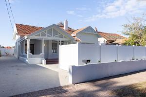 a white fence in front of a house at Belle Escapes Henley's Coastal Charm in Henley Beach South