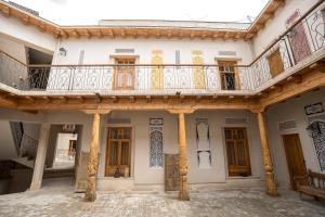 an old building with a balcony and doors at As-Salam Boutique Hotel in Bukhara