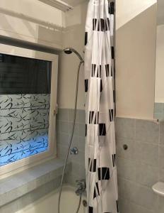 a shower with a black and white shower curtain in a bathroom at Apartments an der Messe in Düsseldorf +7 photos