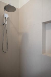 a shower with a shower head in a bathroom at Belle Escapes Henley's Coastal Charm in Henley Beach South +22 photos