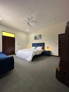a bedroom with a large bed with a blue headboard at Hotel Comfort Hill in Abbottabad