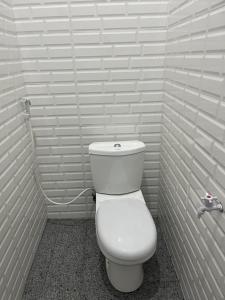 a bathroom with a white toilet in a stall at Nok Homestay in Pangururan +16 photos