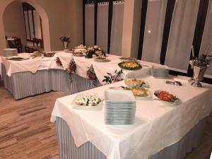 two banquet tables with plates of food on them at Hotel Ristorante La Grotta in Castiglione delle Stiviere