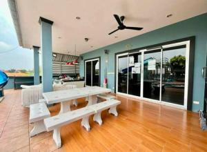 a living room with white benches and a ceiling fan at Splash Paradise Villa in Cha Am