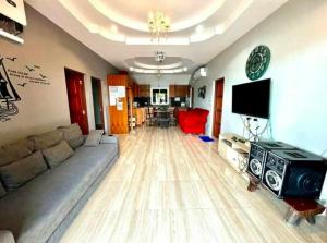 a living room with a couch and a flat screen tv at Splash Paradise Villa in Cha Am