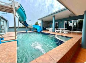 a pool with a slide in a house at Splash Paradise Villa in Cha Am