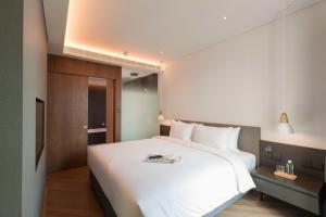 a bedroom with a large white bed in a room at Volve Hotel Bangkok in Bangkok