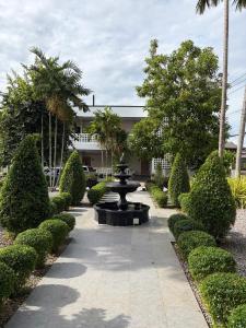 a fountain in the middle of a garden with bushes at VNL Stay in Trang