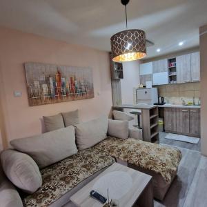 a living room with a couch and a kitchen at Skver apartman in Paraćin +7 photos