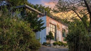 a brick house with a balcony on top of it at Yangyang Little Forest Pension in Yangyang