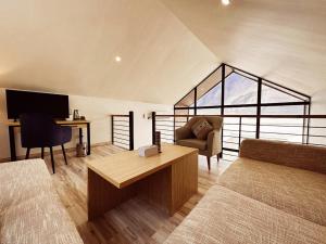 a room with a bed and a desk and a couch at Khoj Resorts Shigar in Shigar