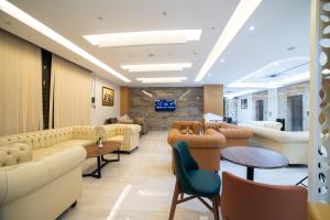 Ein Wartezimmer mit Sofas, Tischen und einem Fernseher in der Unterkunft Barkat hôtel in Baraki