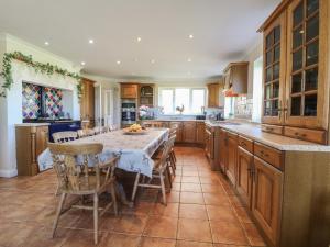 a kitchen with a table and some chairs and a counter at Tixall Manor Farm in Stafford
