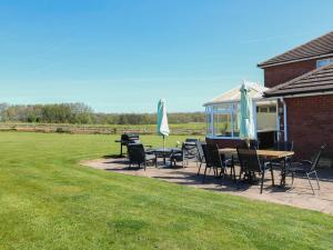a patio with tables and chairs and a gazebo at Tixall Manor Farm in Stafford