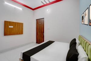 a bedroom with a bed and a wooden door at SPOT ON NEW GANGA HOTEL in Kāsganj