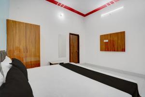 a bedroom with a white bed and wooden doors at SPOT ON NEW GANGA HOTEL in Kāsganj