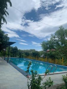 a large blue swimming pool with a fence around it at Educational Eco Ba Vi in Thủ Pháp