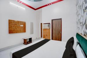 a room with a bed and a wooden door at SPOT ON NEW GANGA HOTEL in Kāsganj +25 photos