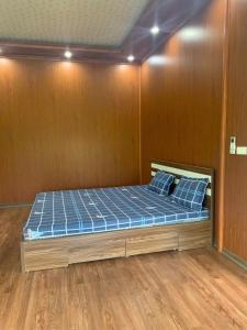 a bed in a room with a wooden wall at Educational Eco Ba Vi in Thủ Pháp +8 photos