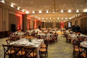 a banquet hall with tables and chairs and a chandelier at Courtyard by Marriott Mexico City Revolucion in Mexico City
