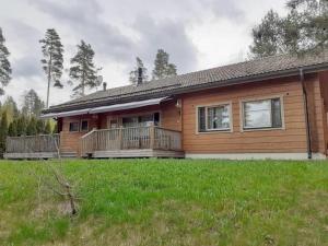 a wooden house with a large deck on a yard at Villa Polly, Jaala, Luxury cottage with private sauna in Kouvola