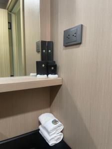 a bathroom with towels on a shelf and a mirror at The Playground in Baras
