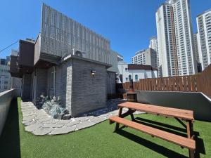 a wooden bench sitting in front of a building at The Van Stay in Busan