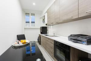 a kitchen with wooden cabinets and a table in it at Domus Arena in Rome