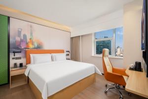 a bedroom with a bed and a desk and a chair at 枫渡酒店上海陆家嘴世纪大道地铁站店 in Shanghai