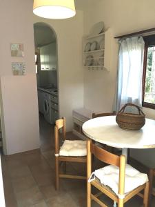 a dining room with a table and chairs and a kitchen at Villaggio Arco in Eraclea Mare