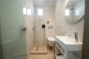 a bathroom with a toilet and a sink and a mirror at White Nest Rooms in Potos +53 photos