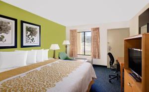 a hotel room with a bed and a flat screen tv at Days Inn by Wyndham Easton in Easton