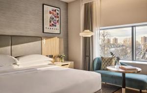 a hotel room with a bed and a table and a window at Hyatt Regency London Olympia in London