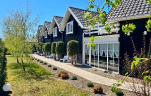 a black house with a pathway in front of it at Bla Marine Domki nad Morzem in Grzybowo