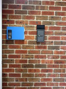 a brick wall with a cell phone on it at Private Room-2Queen beds in Elderslie