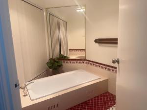 a bathroom with a tub and a large mirror at Private Room-2Queen beds in Elderslie +32 photos