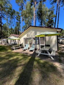 a house with a picnic table and an umbrella at Sosenkowo Domki Letniskowe in Pobierowo