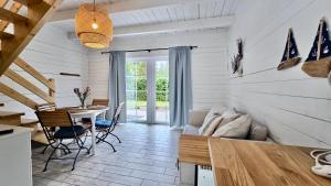 a living room with a table and a couch at Bla Marine Domki nad Morzem in Grzybowo