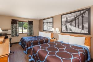 a hotel room with two beds and a desk at Super 8 by Wyndham Elkhart in Elkhart