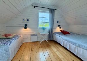 two beds in a room with a window at Bla Marine Domki nad Morzem in Grzybowo